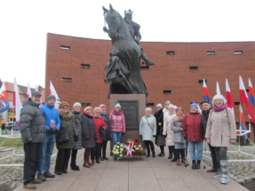 Grupa uczestników heppeningu pod pomnikiem króla Kazimierza Wielkiego